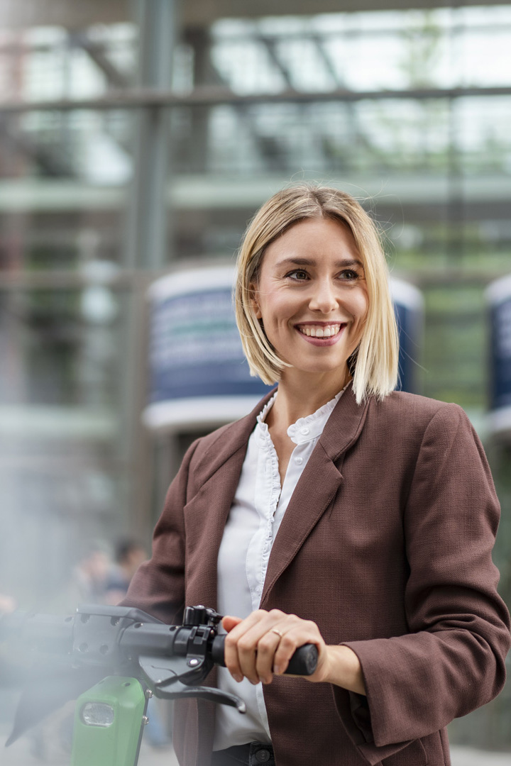 about_happy-young-businesswoman-with-e-scooter-in-the-ci-2022-12-16-22-45-38-utc